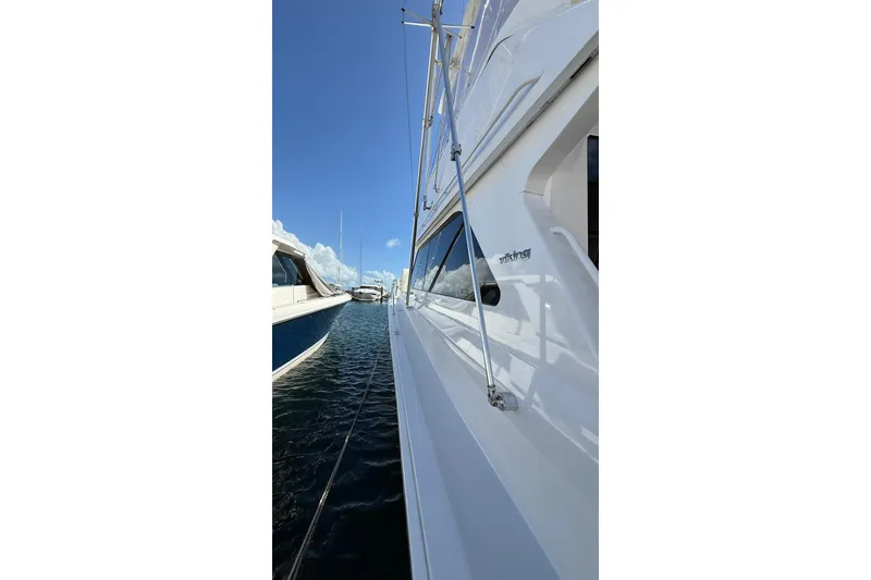 Slide: The Image of Side view of a 1999 Viking 50 Convertible yacht docked in a marina. - 3