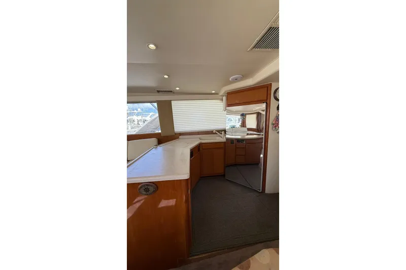 Slide: The Image of Interior of 1999 Viking 50 Convertible yacht with modern kitchen and wooden cabinetry. - 9