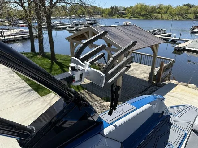 Slide: The Image of Cobalt R6 Surf 2026 boat with wakeboard rack by the lake. - 43