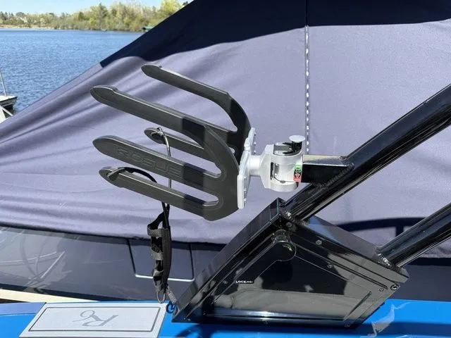 Slide: The Image of Cobalt R6 Surf 2026 boat with wakeboard rack by the lake. - 44