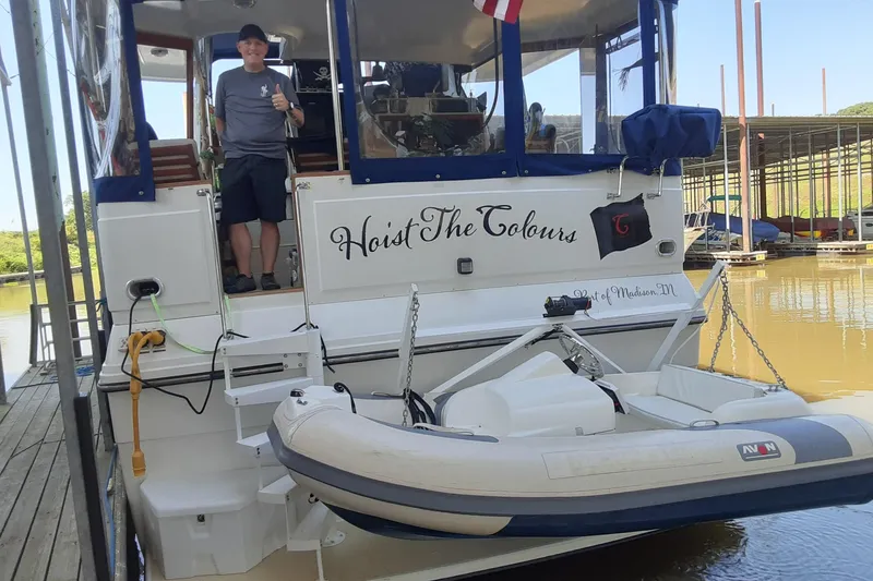 Slide: The Image of 1991 Carver 42 Aft Cabin Motor Yacht with dinghy, docked, person giving thumbs up. - 41