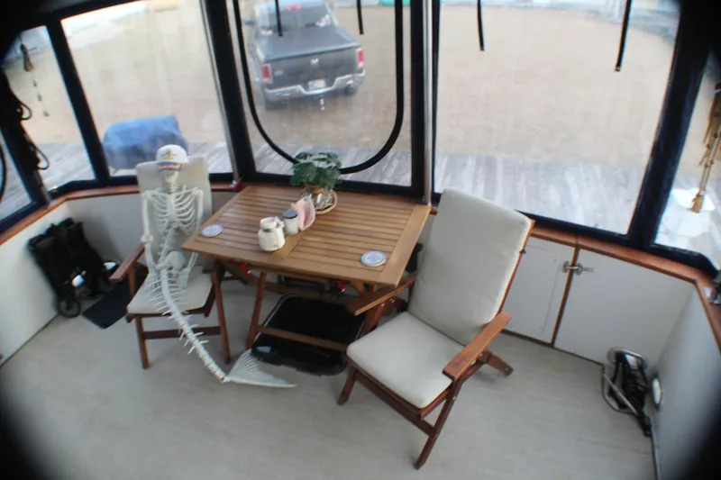 Slide: The Image of 1991 Carver 42 Aft Cabin Motor Yacht interior with skeleton decor at table. - 32