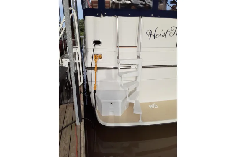 Slide: The Image of 1991 Carver 42 Aft Cabin Motor Yacht stern with spiral staircase and dock connection. - 40