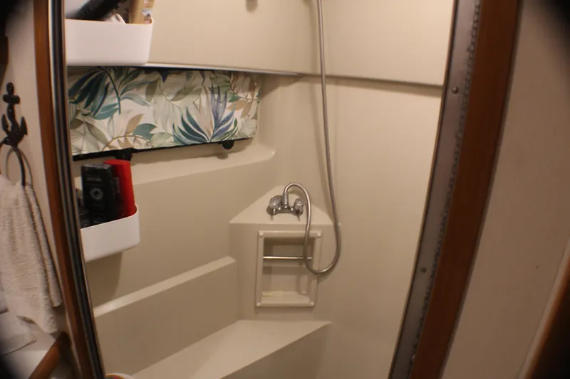 Slide: The Image of 1991 Carver 42 Aft Cabin Motor Yacht bathroom with shower and storage shelves. - 46