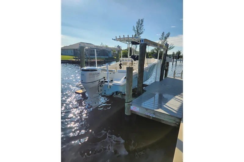 Slide: The Image of 2023 Bulls Bay 230 Center Console boat docked with Suzuki outboard motor. - 2