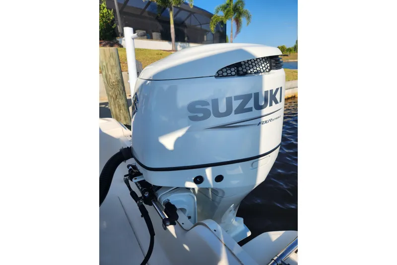 Slide: The Image of 2023 Bulls Bay 230 Center Console with Suzuki outboard motor by the water. - 4