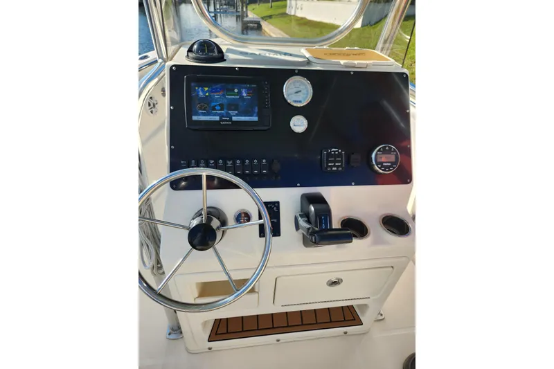 Slide: The Image of 2023 Bulls Bay 230 Center Console boat dashboard with steering wheel and navigation controls. - 6