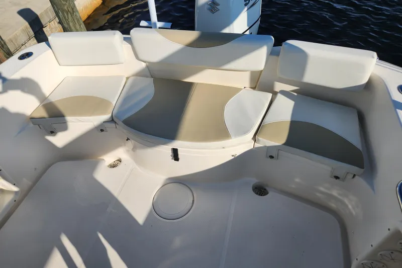 Slide: The Image of 2023 Bulls Bay 230 Center Console boat seating area with cushioned seats and storage. - 9