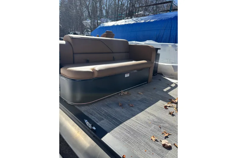 The Image of 2026 Avalon Venture Cruise Rear Bench with brown seating, outdoor setting, fallen leaves. - 0