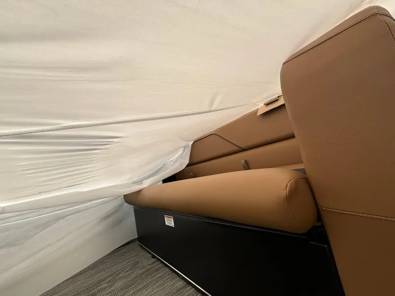 Slide: The Image of 2025 Avalon Venture Cruise Rear Bench with brown upholstery under a protective cover. - 6