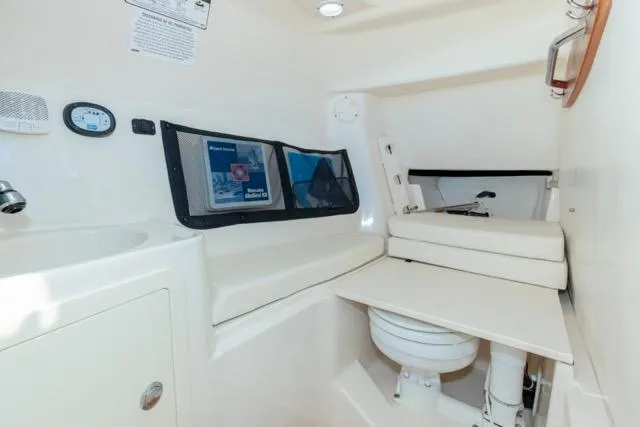 Slide: The Image of 2017 Grady-White Freedom 307 boat interior with compact bathroom and storage. - 10