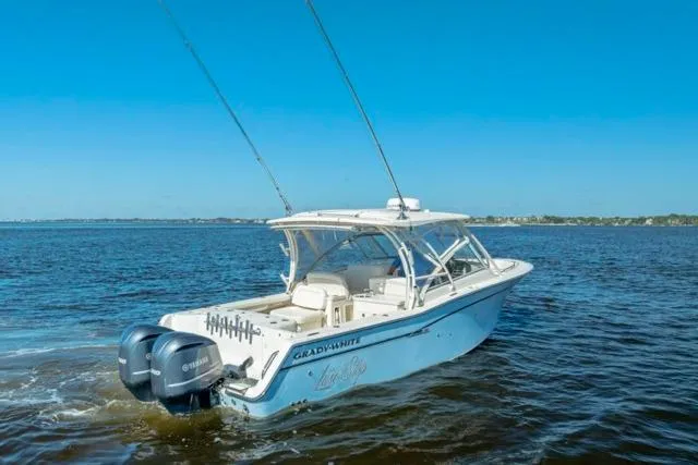 Slide: The Image of 2017 Grady-White Freedom 307 boat cruising on open water under clear blue skies. - 33