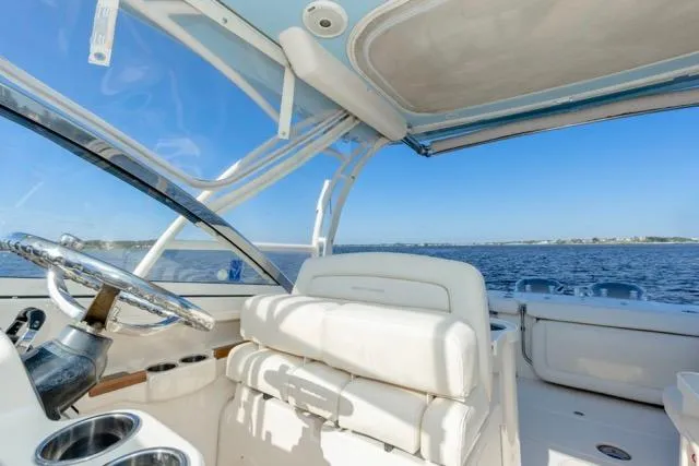 Slide: The Image of 2017 Grady-White Freedom 307 boat interior with ocean view, featuring white seating and steering wheel. - 4