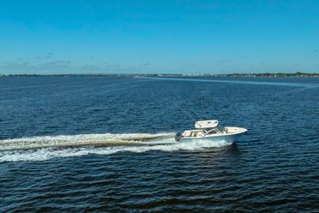 Slide: The Image of 2017 Grady-White Freedom 307 boat cruising on open water under clear blue sky. - 47