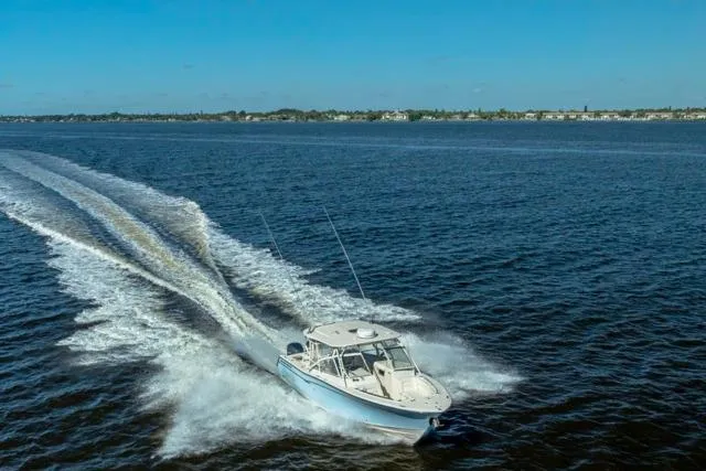 Slide: The Image of 2017 Grady-White Freedom 307 boat cruising on open water under clear blue skies. - 49
