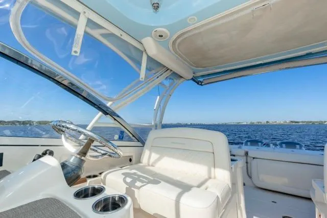 Slide: The Image of 2017 Grady-White Freedom 307 boat interior with ocean view, featuring helm and seating area. - 5