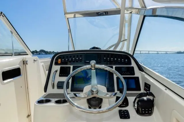 Slide: The Image of 2017 Grady-White Freedom 307 boat helm with steering wheel and control panel, ocean view. - 7