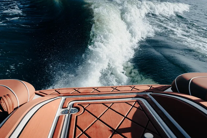 Slide: The Image of Wake behind MB B52 23 Alpha boat, 2026 model, with teak deck and cushioned seats. - 11