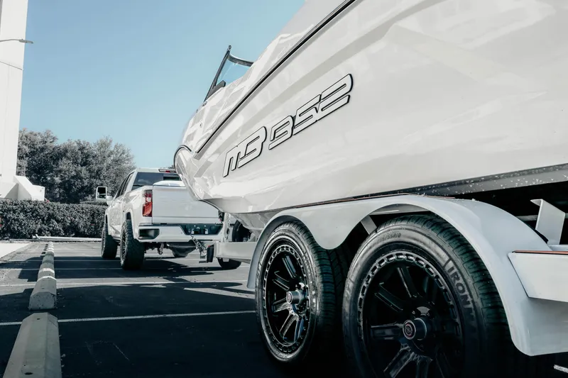 Slide: The Image of 2026 MB B52 23 Alpha boat on trailer, parked beside a white truck. - 18