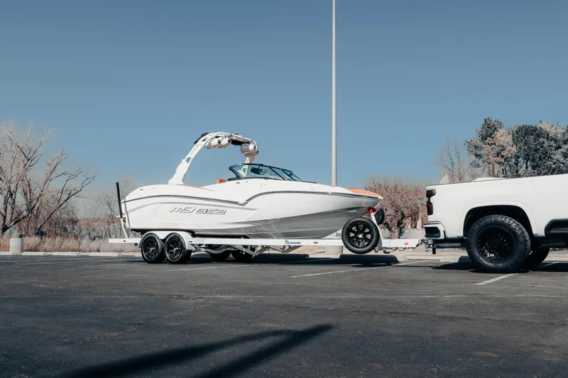 Slide: The Image of 2026 MB B52 23 Alpha boat on trailer, hitched to white truck in parking lot. - 19