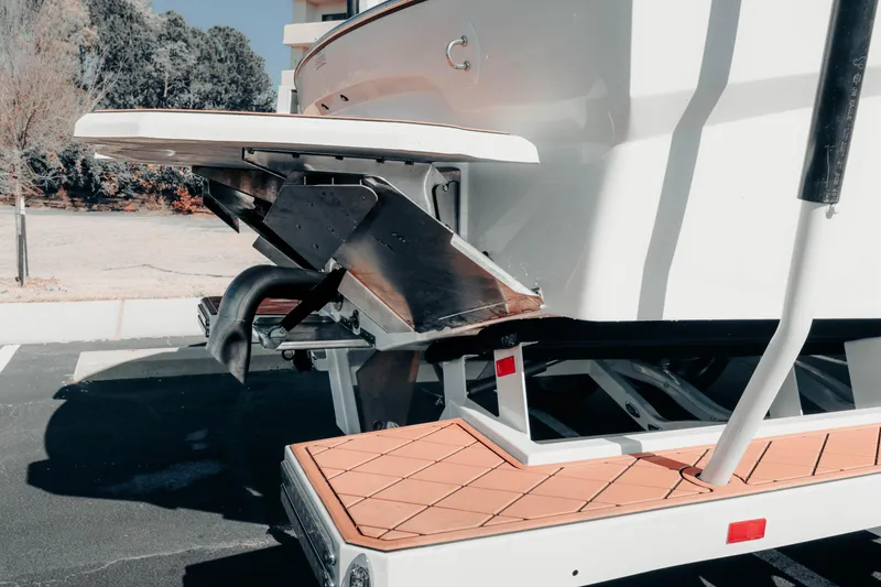 Slide: The Image of 2026 MB B52 23 Alpha boat rear view with trailer, showcasing sleek design and features. - 22