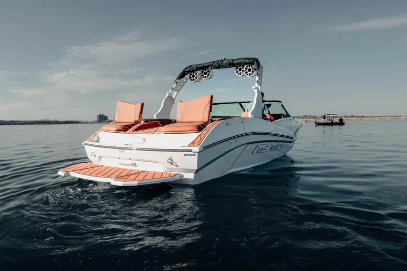 Slide: The Image of 2026 MB B52 23 Alpha boat on calm water, featuring sleek design and orange seating. - 7