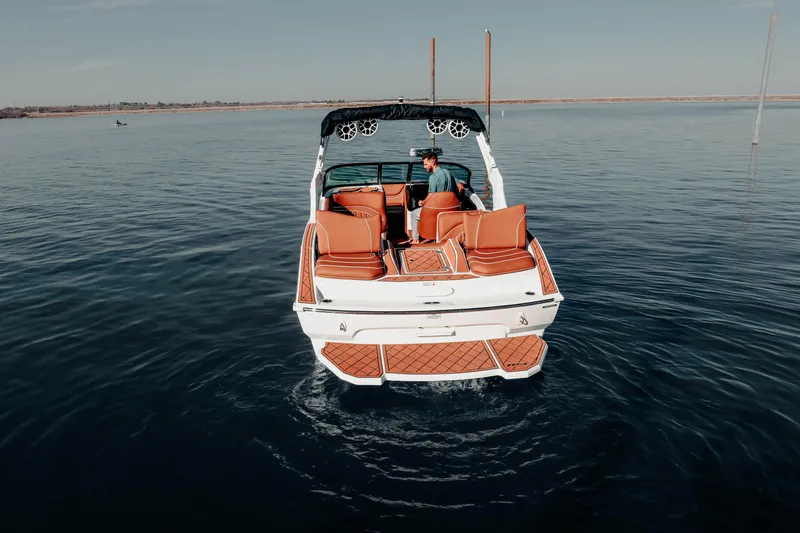 Slide: The Image of 2026 MB B52 23 Alpha boat on calm water, featuring orange seating and sleek design. - 9