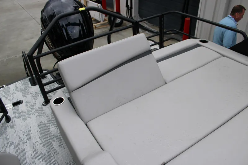 Slide: The Image of 2026 Starcraft SLS 3 Q DH boat with cushioned seating and cup holders, docked outdoors. - 15