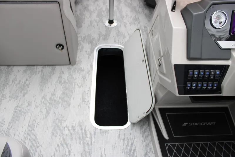 Slide: The Image of 2026 Starcraft SLS 3 Q DH boat interior with open storage compartment and control panel. - 19