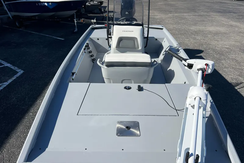 Slide: The Image of 2026 Tracker Bass Tracker Classic CC boat with seating and trolling motor in a parking lot. - 49