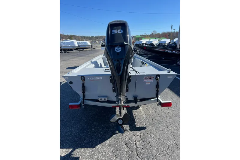 Slide: The Image of 2026 Tracker Bass Tracker Classic CC boat with outboard motor, parked outdoors. - 51