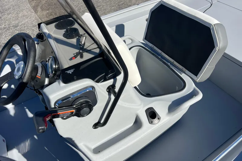 Slide: The Image of 2026 Tracker Bass Tracker Classic CC boat console with steering wheel and open storage compartment. - 53