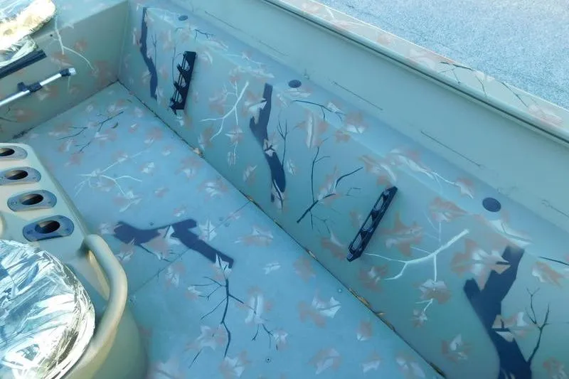 Slide: The Image of 2024 Tracker Grizzly 2072 CC interior with camouflage design and rod holders. - 11