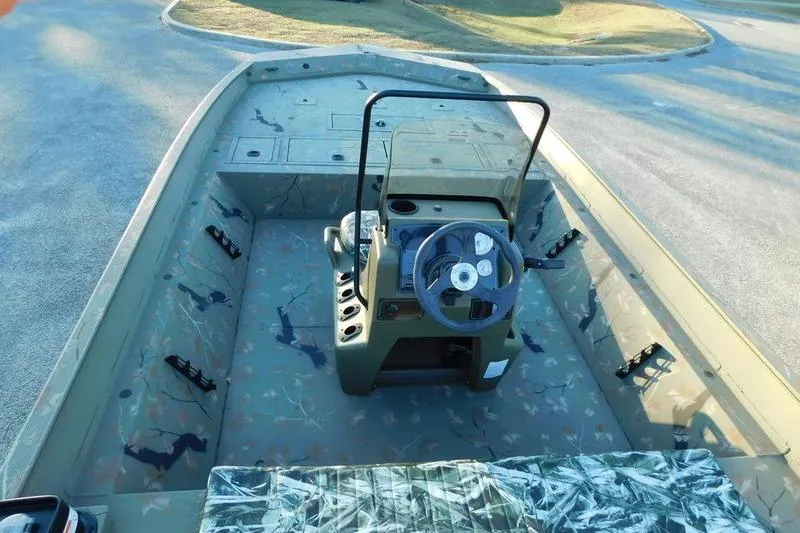 Slide: The Image of 2024 Tracker Grizzly 2072 CC boat interior with camouflage design and steering console. - 12
