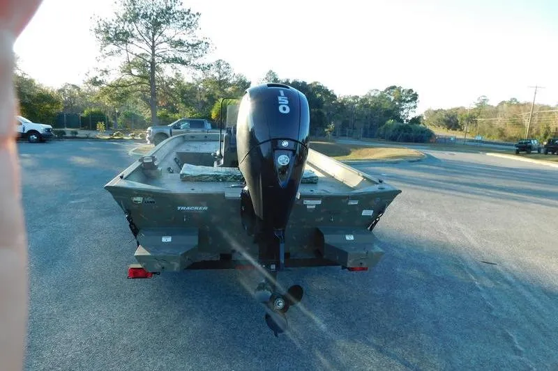 Slide: The Image of 2024 Tracker Grizzly 2072 CC boat with 150 HP outboard motor in a parking lot. - 5