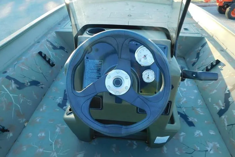 Slide: The Image of 2024 Tracker Grizzly 2072 CC boat dashboard with steering wheel and gauges. - 8
