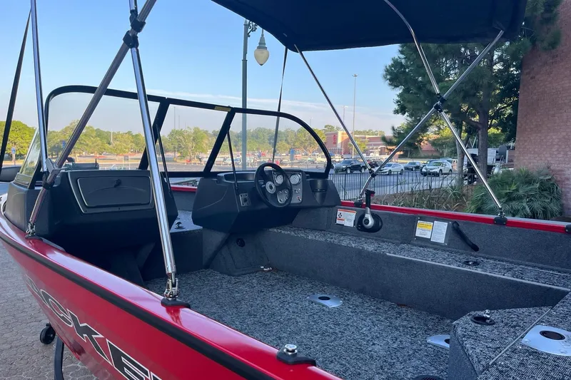 Slide: The Image of 2026 Tracker Pro Guide V-16 WT boat interior with canopy, parked outdoors. - 6