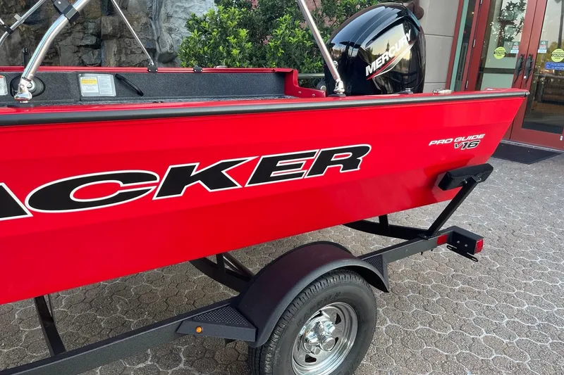 Slide: The Image of Red 2026 Tracker Pro Guide V-16 WT boat on trailer, featuring Mercury engine. - 5