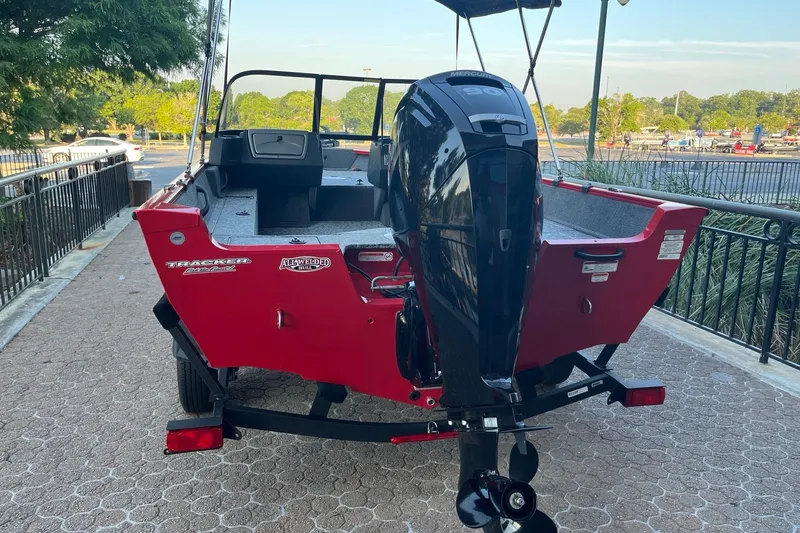 Slide: The Image of 2026 Tracker Pro Guide V-16 WT boat with Mercury engine, parked on a paved path. - 7