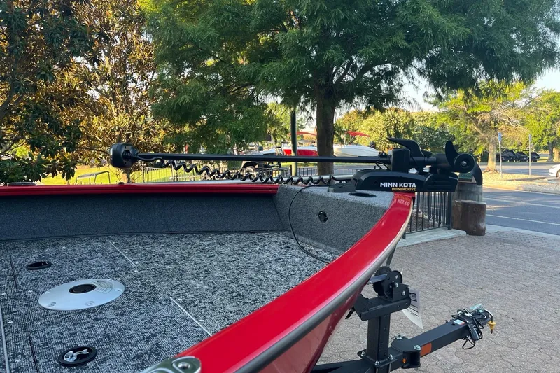 Slide: The Image of 2026 Tracker Pro Guide V-16 WT boat with Minn Kota trolling motor in a scenic outdoor setting. - 2
