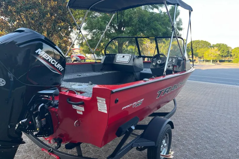 Slide: The Image of 2026 Tracker Pro Guide V-16 WT boat with Mercury engine, parked outdoors. - 4