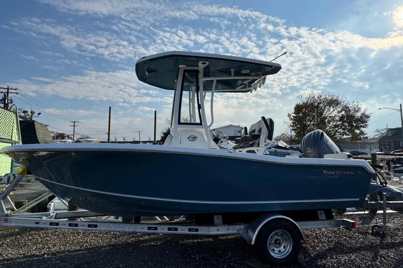 The Image of 2026 Tidewater 198 CC Adventure boat on trailer under a partly cloudy sky. - 0