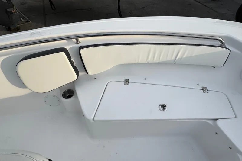 Slide: The Image of 2026 Tidewater 198 CC Adventure boat interior with white cushioned seating and storage compartment. - 16
