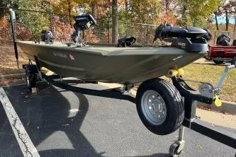 Slide: The Image of 2022 Tracker Grizzly 1648 AWL boat on trailer in parking lot. - 2