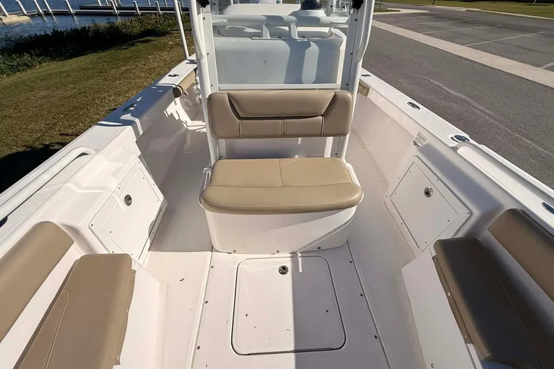 Slide: The Image of 2019 Everglades 243 Center Console boat interior with beige seating and storage compartments. - 12