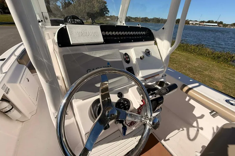 Slide: The Image of 2019 Everglades 243 Center Console boat dashboard with steering wheel and controls by the water. - 7