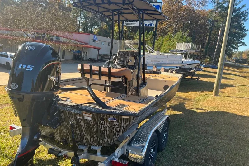 Slide: The Image of 2026 Avid 20 ROGUE CC boat with Yamaha 115 engine on trailer, outdoor setting. - 2