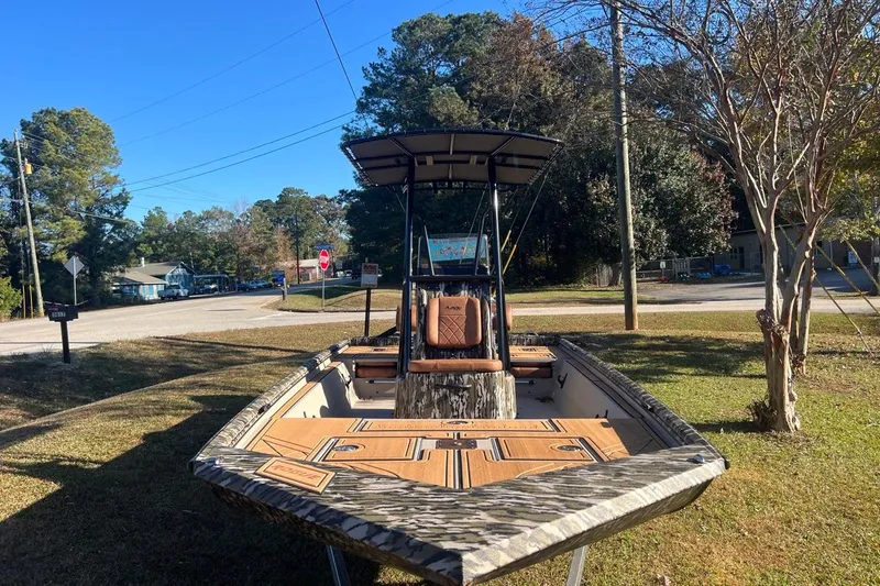 Slide: The Image of 2026 Avid 20 ROGUE CC boat parked outdoors on grass, surrounded by trees and street. - 7