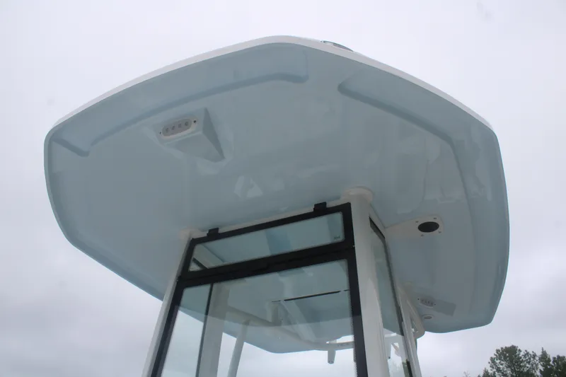 Slide: The Image of 2026 Tidewater 210 LXF boat's T-top and windshield against cloudy sky. - 10