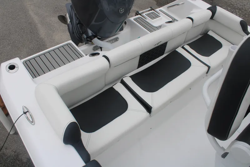 Slide: The Image of 2026 Tidewater 210 LXF boat interior with cushioned seating and motor. - 12